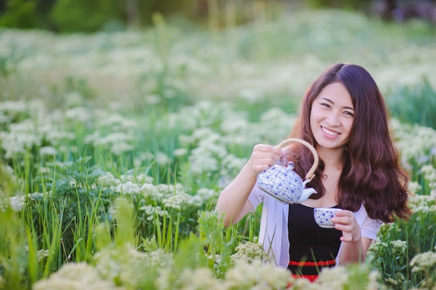 Jeune, chinois, girl, Verser, thé, fleurir, pré