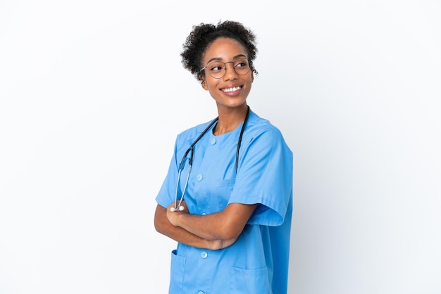 Jeune chirurgien femme médecin afro-américaine isolée sur fond blanc avec les bras croisés et heureux