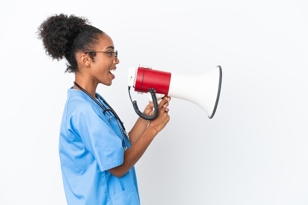 Jeune chirurgien femme médecin afro-américaine isolée sur fond blanc criant à travers un mégaphone