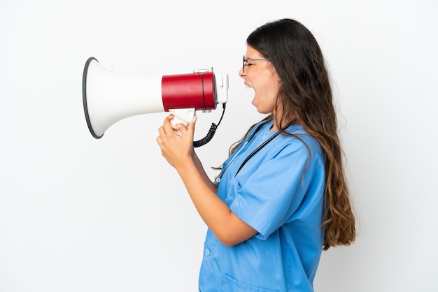 Jeune chirurgien médecin femme caucasienne isolée sur fond blanc criant à travers un mégaphone