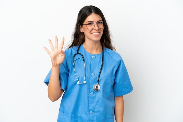 Jeune chirurgien médecin femme caucasienne isolée sur fond blanc heureux et comptant quatre avec les doigts