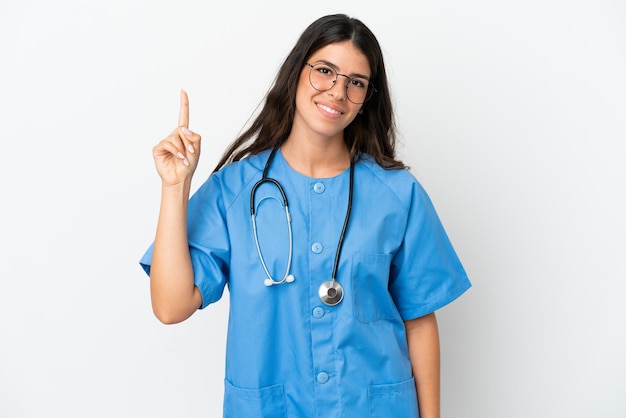 Jeune chirurgien médecin femme caucasienne isolée sur fond blanc montrant et levant un doigt en signe du meilleur