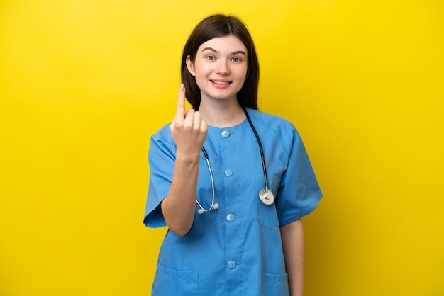 Jeune chirurgien médecin femme russe isolée sur fond jaune faisant un geste à venir