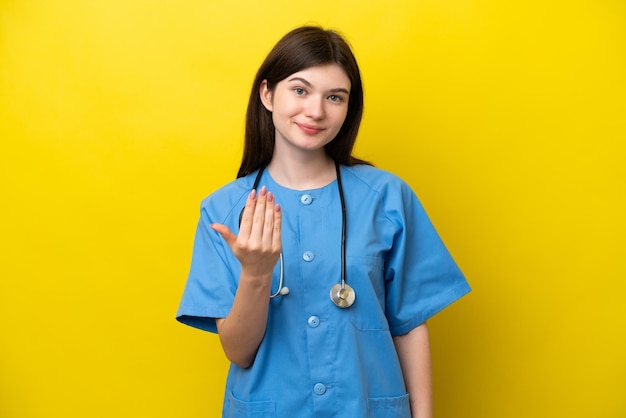 Jeune chirurgien médecin femme russe isolée sur fond jaune invitant à venir avec la main Heureux que vous soyez venu