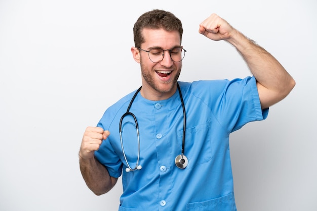 Jeune chirurgien médecin homme caucasien isolé sur fond blanc célébrant une victoire