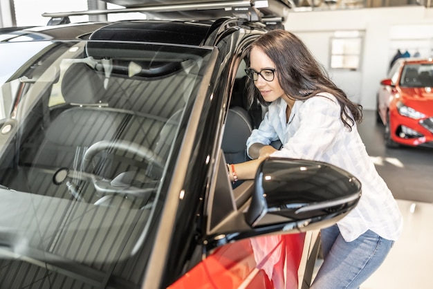 Un jeune client profite de l'inspection d'une nouvelle voiture dans le magasin