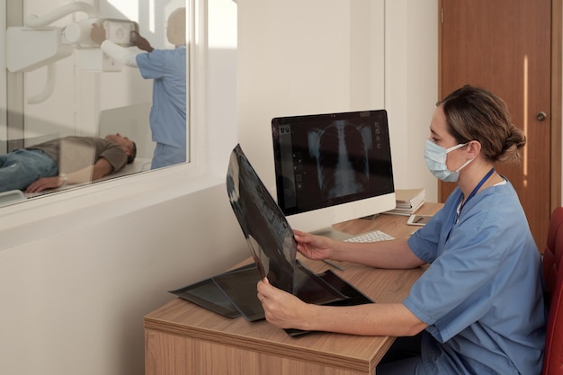 Jeune clinicienne regardant des images radiographiques de patients par lieu de travail