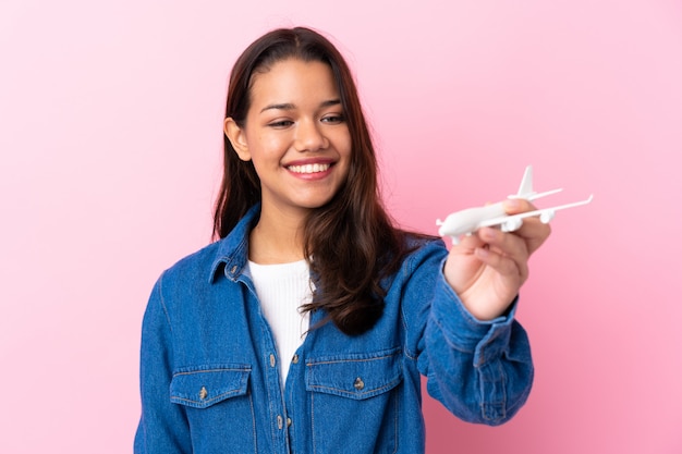 Jeune, colombien, girl, tenue, jouet, avion, isolé, mur