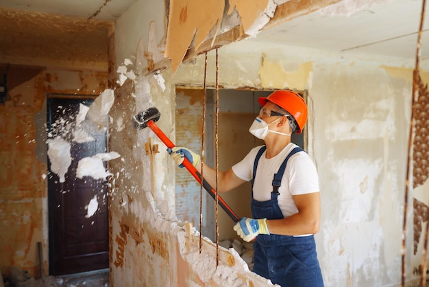 Jeune constructeur masculin dans un casque tenant des outils Concept de réparation et de rénovation d'appartement