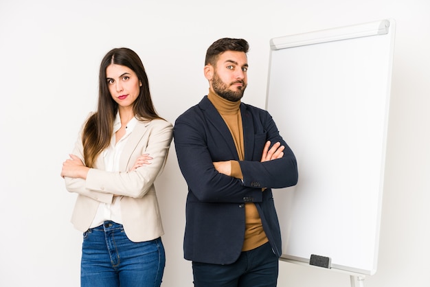 Jeune couple d'affaires caucasien isolé malheureux à la recherche à huis clos avec une expression sarcastique.