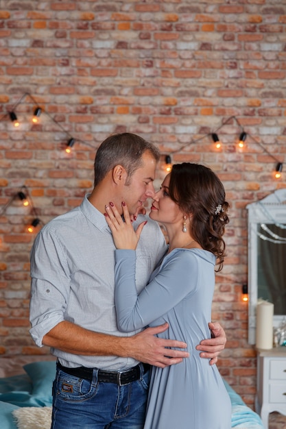 Jeune couple affectueux s'embrassant tendrement en studio.