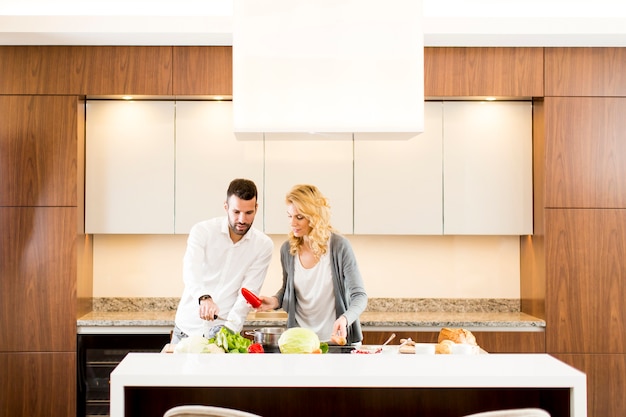 Jeune couple aimant préparer un délicieux repas dans une cuisine moderne