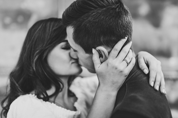 Jeune couple aimant s'embrasser et se serrer dans ses bras à l'extérieur de la Saint-Valentin. Amour et tendresse, rencontres, romance, famille, concept d'anniversaire. Photographie en noir et blanc.