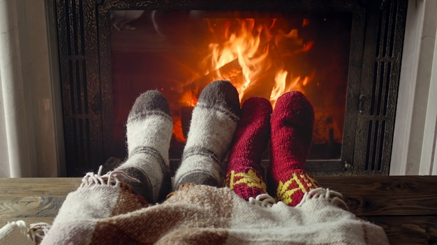 Jeune couple amoureux allongé sous une couverture au coin du feu