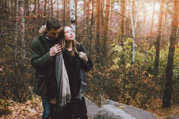 Jeune couple amoureux amis habillés dans un style décontracté marchant ensemble sur la forêt du parc naturel pendant la saison froide. Sensibilité au concept de la nature