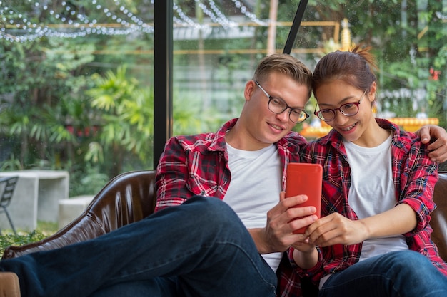 Jeune couple amoureux assis dans un café prend un portrait de selfie avec téléphone appareil photo