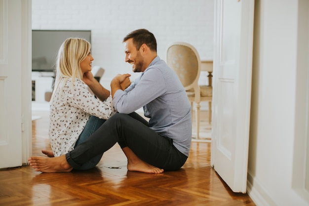 Jeune couple d&#39;amoureux assis sur le sol dans la chambre