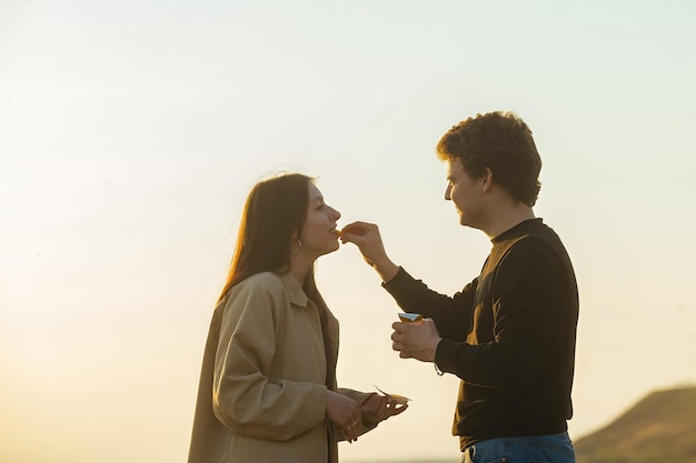 jeune couple amoureux dans la nature se nourrit de restauration rapide