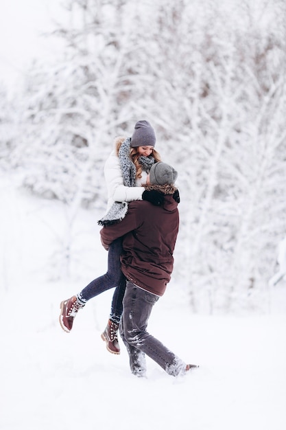 Jeune couple amoureux de l'hiver enneigé en plein air