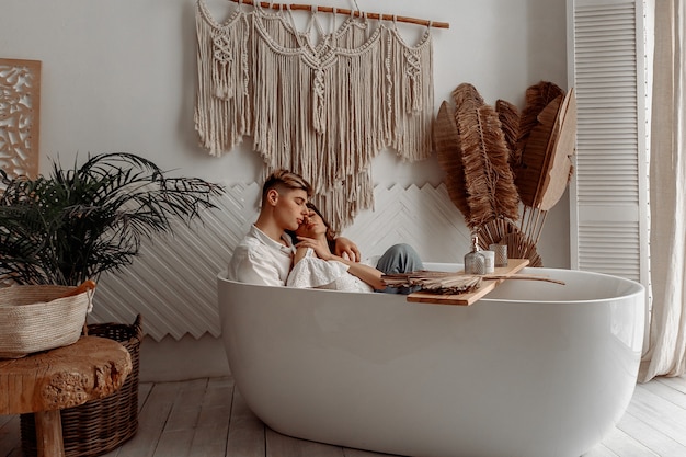 Jeune couple amoureux à l'intérieur d'une baignoire luxueuse.