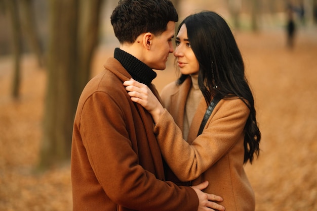 Jeune couple amoureux marchant dans le parc un jour d'automne profitant du temps ensemble
