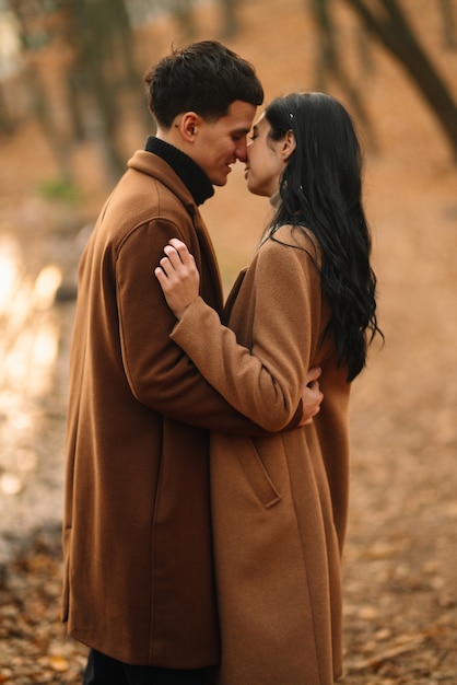 Jeune couple amoureux marchant dans le parc un jour d'automne