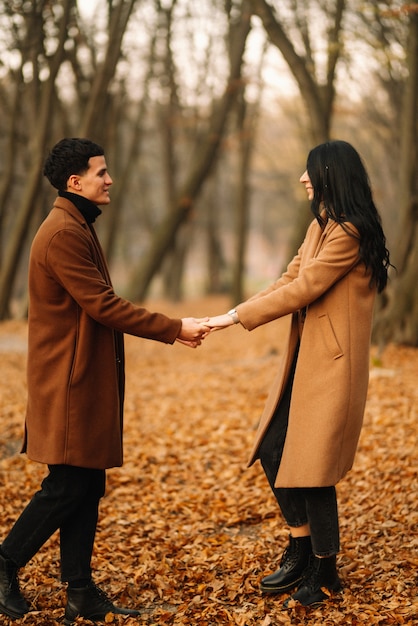 Jeune couple amoureux marchant dans le parc un jour d'automne