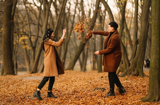 Jeune couple amoureux marchant dans le parc un jour d'automne