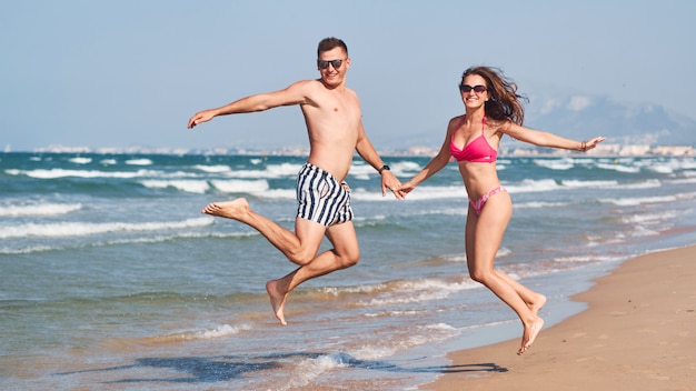 Jeune couple amoureux marchant sur la plage.