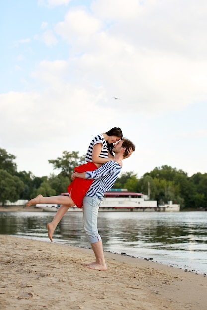 Photo jeune couple amoureux sur la plage d'été