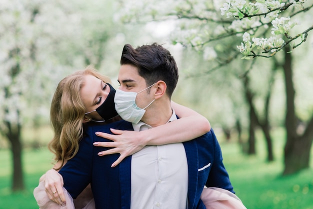 Jeune couple d'amoureux portant des masques le jour de leur mariage