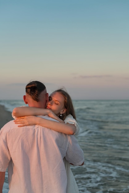 Jeune couple amoureux s'embrassant sur la plage en été