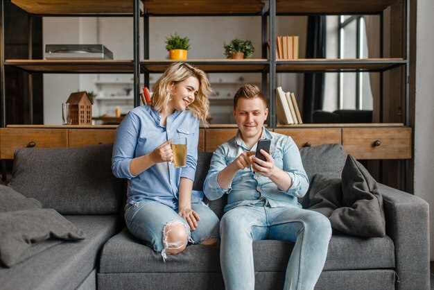 Jeune couple amoureux se détendre sur le canapé à la maison.