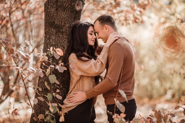 jeune couple amoureux se promenant dans la forêt d'automne