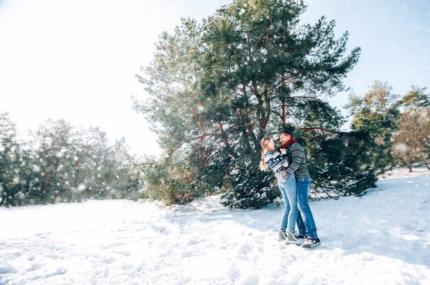 Un jeune couple amoureux se repose dans les montagnes dans une forêt enneigée. concept de repos articulaire