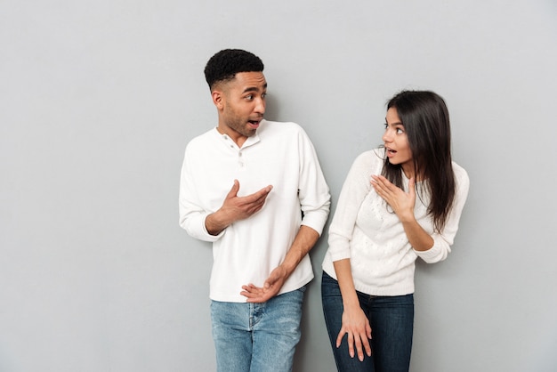 Jeune couple d'amoureux surpris se regardant.