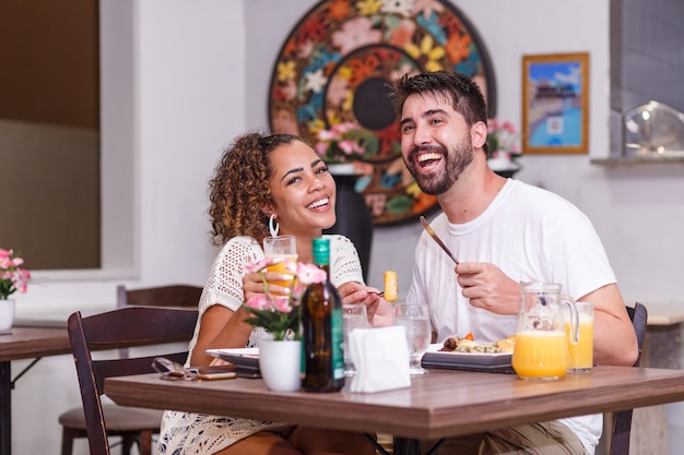 Jeune couple d'amoureux en train de dîner au restaurant.