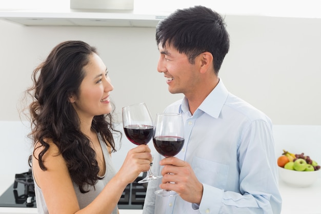Jeune couple d&#39;amoureux avec des verres à vin dans la cuisine