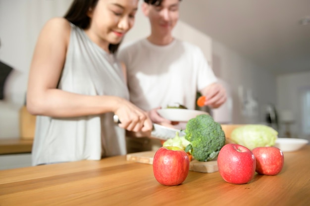 Un jeune couple asiatique aime cuisiner avec des ingrédients sains de légumes et de fruits dans la cuisine