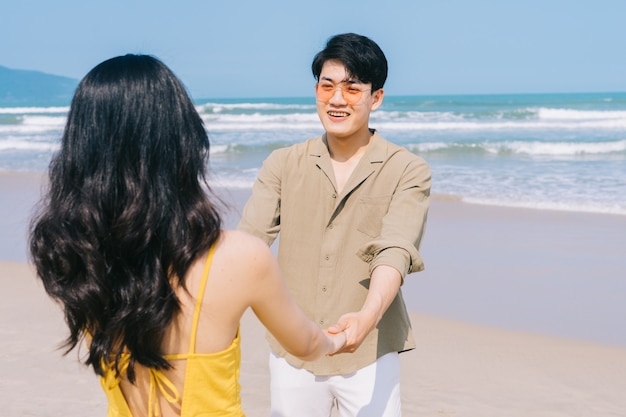 Jeune couple asiatique bénéficiant de vacances d'été sur la plage