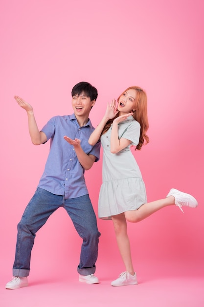 Jeune couple asiatique posant sur fond rose