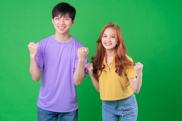 Jeune couple asiatique posant sur fond vert