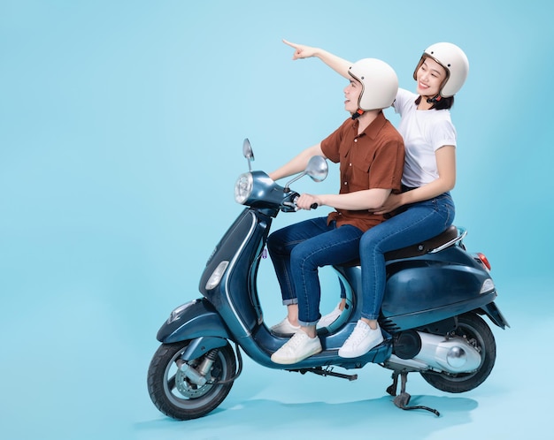 Jeune couple asiatique ride scooter sur fond