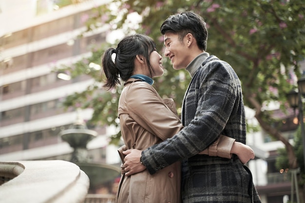 Photo un jeune couple asiatique s'embrassant à l'extérieur.