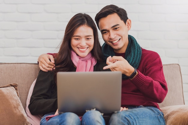 Jeune couple asiatique, shopping en ligne avec ordinateur portable