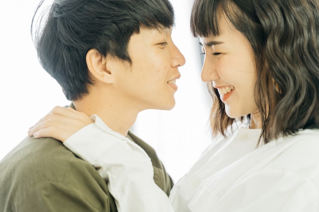 Photo jeune couple asiatique souriant avec heureux ensemble sur blanc