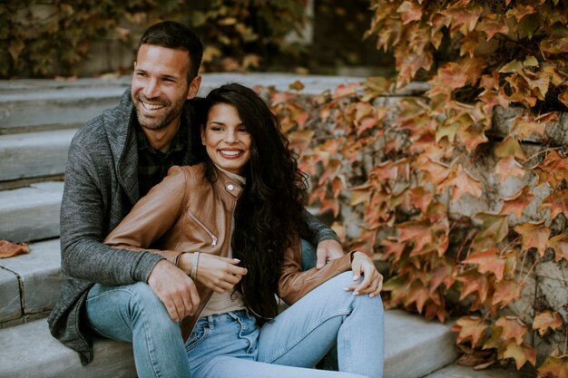 Jeune couple assis sur les escaliers au jour d'automne