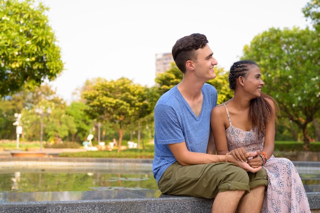 Photo un jeune couple assis à l'extérieur