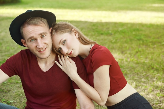 jeune couple assis à proximité dans l'herbe