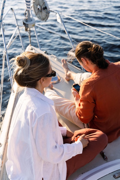 Un jeune couple attrayant se détend sur le voilier pendant la navigation en mer